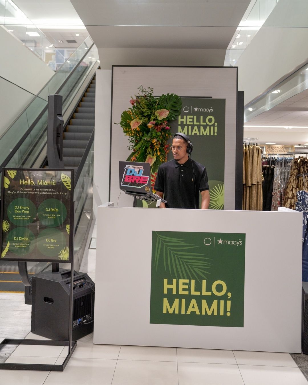 DJ BRE performing behind a HELLO, MIAMI! booth at Macy's Aventura